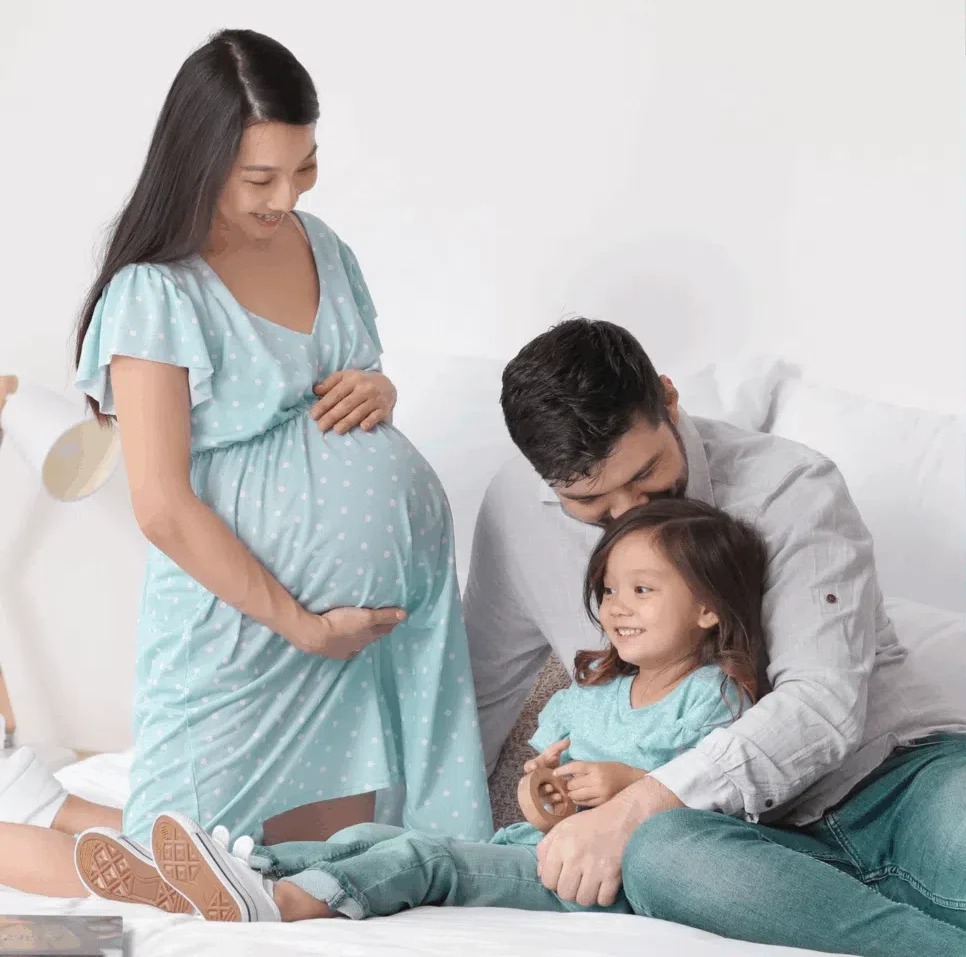 Family of pregnant mom, dad, and a little girl.